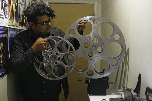 Pedro Robles-Hill compares 35-millimeter to 70-millimeter reels at the Loft Cinema's projection booth in Tucson on Oct. 10, 2016. Each reel holds only one part of a movie, with an average of eight reels needed for an entire film. (Photo by Alexis Wright / Arizona Sonora News)