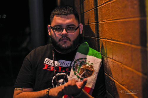 Manuel “Spit Hell” Andrade, poses with a Mexican flag to show his solidarity to his hispanic heritage. (Photo by Chas Wright)