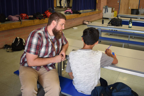 Daniel Johnson helps a student at Hollinger K-8 in Tucson, AZ. (Photo by: Bria Fonteno / Arizona Sonora News)
