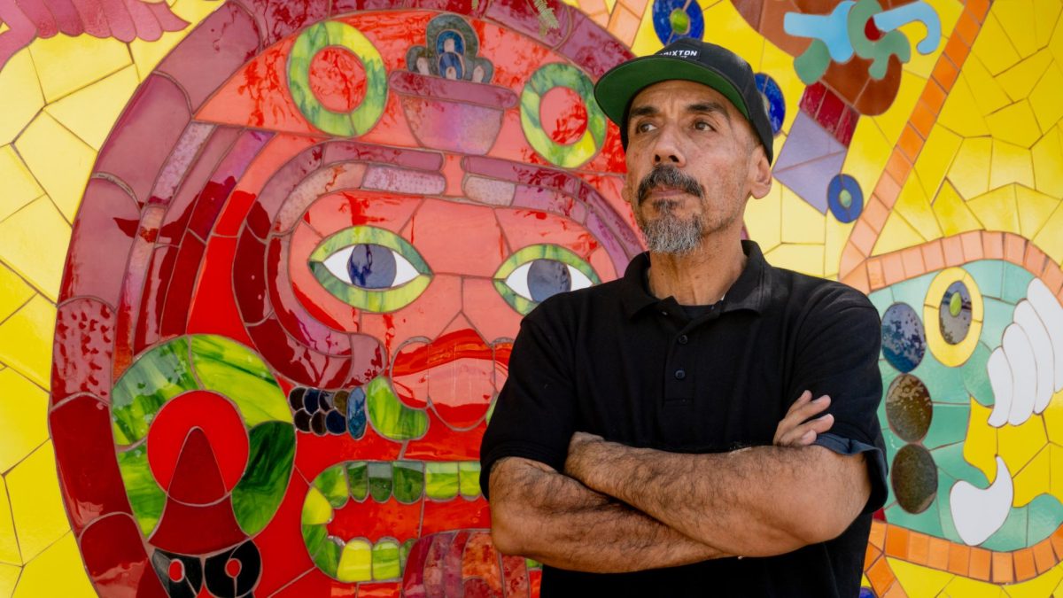 Carlos Valenzuela stands in front of "The sun, the moon and the star," one of his vibrant tile murals in the city of South Tucson, visible on 26th Street. 