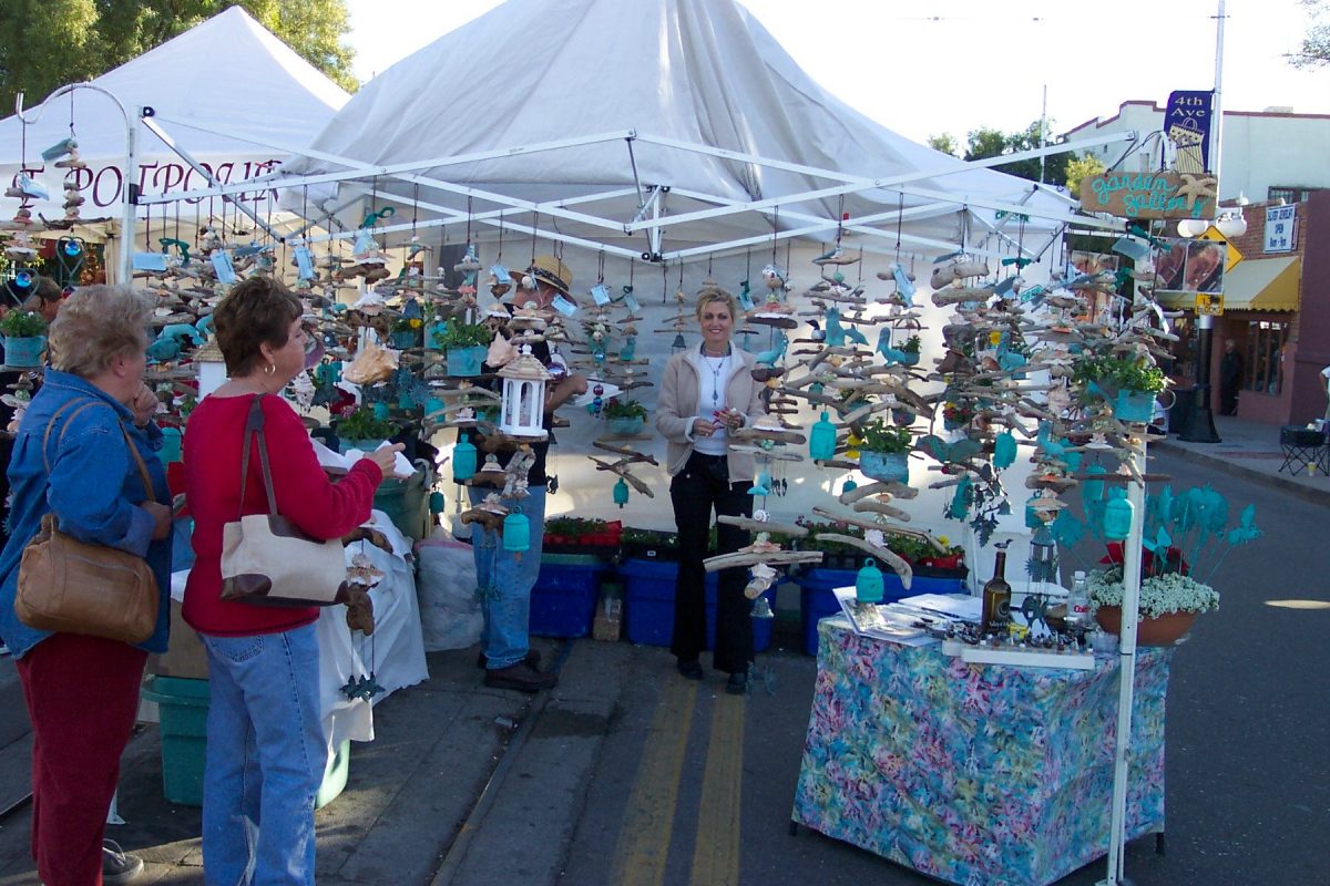 Visitors observing an artist’s booth at the winter street fair. Courtesy Fourth Avenue Merchants Association via Casey Anderson.