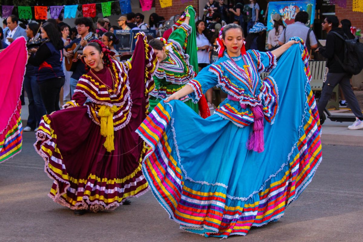 Las bailarinas del Grupo Folklórico Miztontli, Isabela Manuel (izquierda) y Olivia Renteria (derecha), se presentan en el evento Encuentro de la Universidad de Arizona el 18 de septiembre, frente al edificio César E. Chávez.