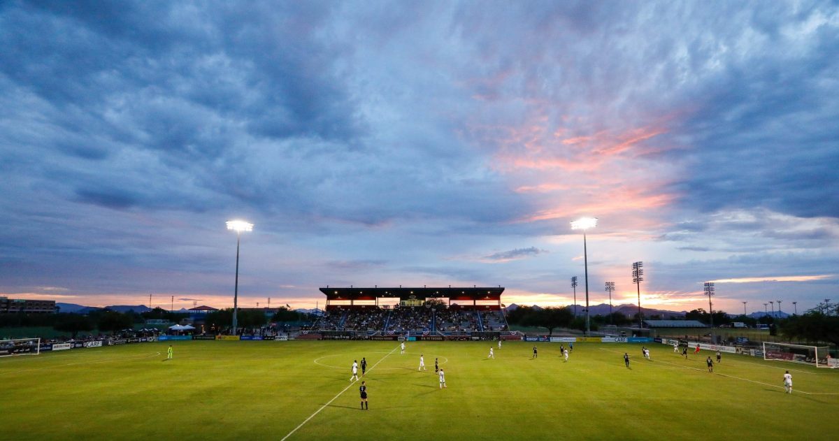 Kino Sports Complex hosts a sunset showdown as stadium lights rise over the pitch and players compete beneath a colorful desert sky in Tucson. (Courtesy of FC Tucson)