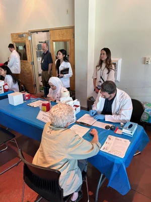 A woman speaks with a doctor at an Asian health fair sponsored by the  Tucson Chinese Cultural Center. The center is turning to community events to raise money to expand the health care program after losing federal funding. 
