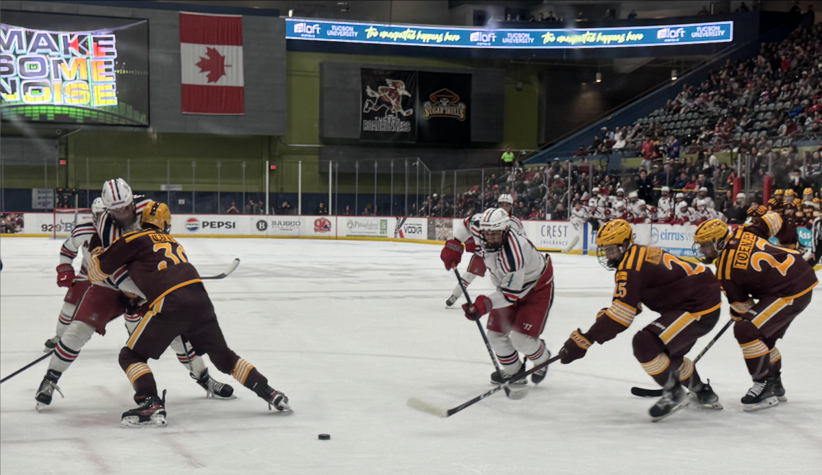 Forward Jacob Vockler, center, makes an attempt at a shot against ASU in the third period of the Wildcats season finale in Tucson Arena on Feb. 20. The Wildcats lost this match 1-0. 