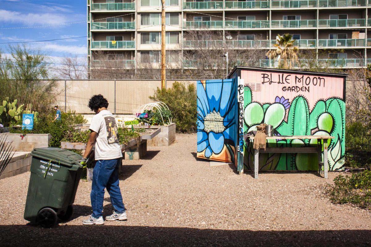 A gardener moves a bin filled with plant debris at Blue Moon Garden in Tucson, Ariz. on Feb. 15, 2026. Blue Moon is a community garden located south of Tucson House in Barrio Blue Moon, with a three-bin composting system available to gardeners.