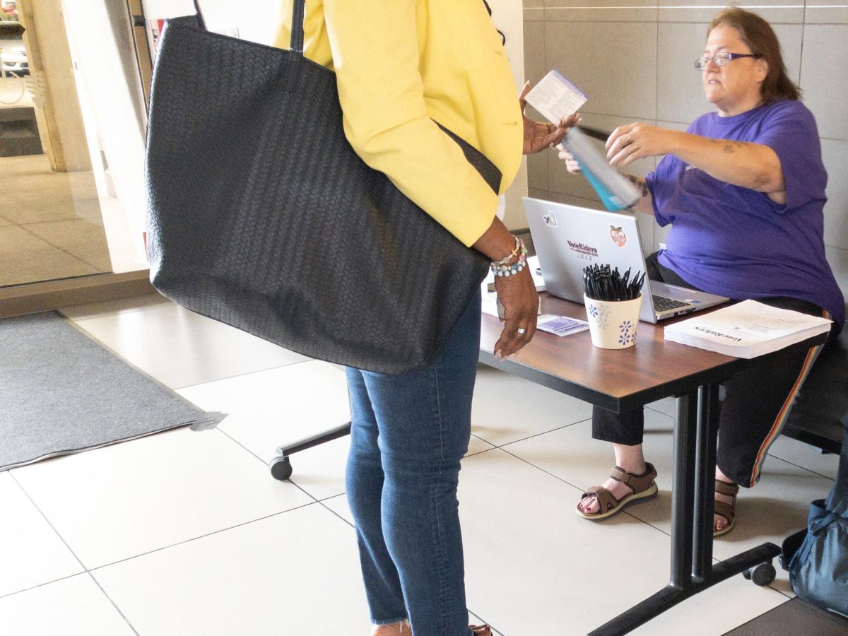 Valerie ElGhaouti, a paid organizer for VoteRiders, talks to a visitor at the Murphy-Wilmot Library in Tucson, Ariz. on March 10, 2026. ElGhaouti said the number of people she talks to can vary from none to nearly 20, depending on the day.